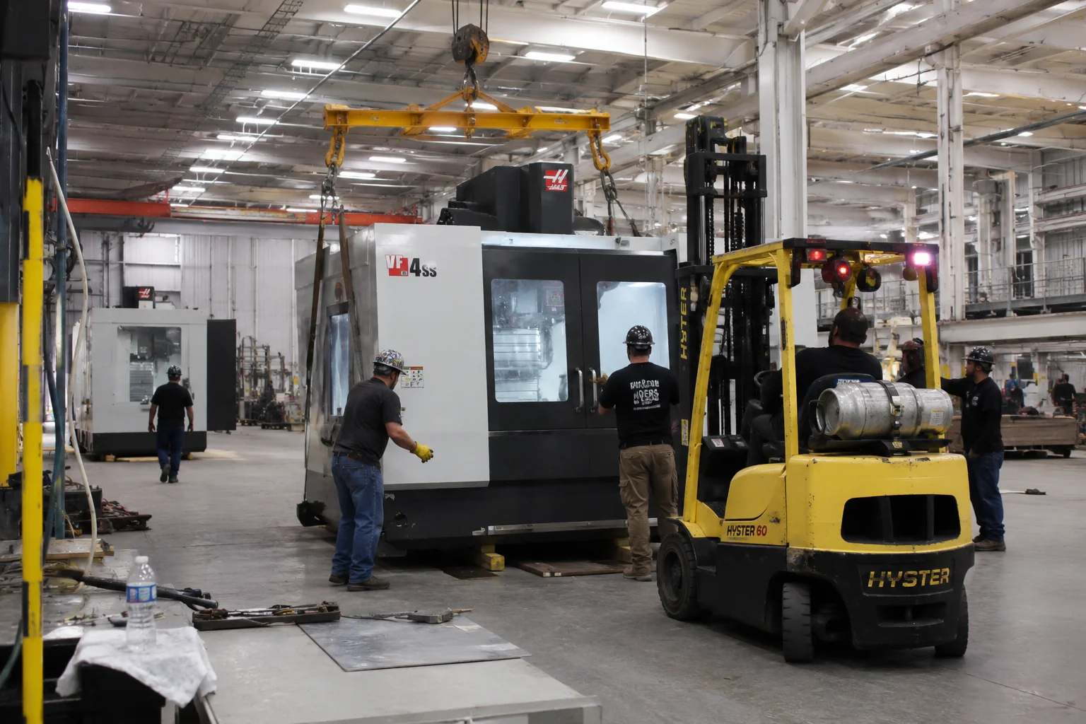 Manufacturing equipment relocation in progress inside an industrial facility with heavy machinery being moved safely.